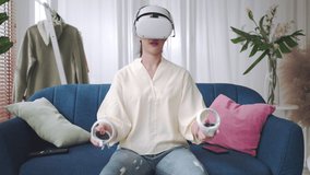 Young woman using glasses of metaverse virtual reality at home.asian girl using Smartphone with VR headset,virtual reality,future technology concept.Asian woman using VR glasses in living room.