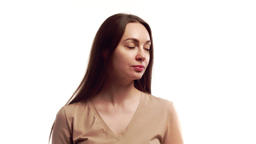 Beautiful woman smile and looks into camera and adjusts long lush hair, on white background in studio, front view. Concept of beauty