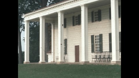 1960s: Mansion back porch. Chairs lined against house on backyard patio. Mount Vernon backyard. Columns on porch.