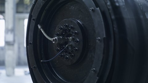Rubber tyre production machine in technological automotive factory closeup. Close up tire manufacturing mechanism before working process with tape at workshop. Automobile equipment product concept