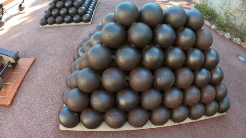 Monaco, October 6, 2021: DOLLY SHOT - Pyramids of cannonballs near Prince Palace in Monaco.Detail on ordered cannonballs. A stack of cannonballs near the royal palace in Monaco.