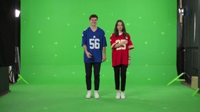A young couple dancing making content on a green screen background. A guy and a girl in love make dance movements synchronously. Modern bloggers are creating a master class. Chroma key