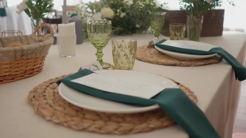 Large shots of the decor on the wedding table in a bright hall. Plates served for the wedding dinner. High quality FullHD footage