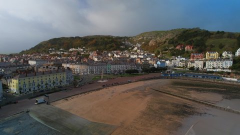 Llandudno village and beach during low tide, North Wales in UK. Aerial forward