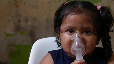 Asian girl about 4 years is being nebulized to cure her respiratory tract.