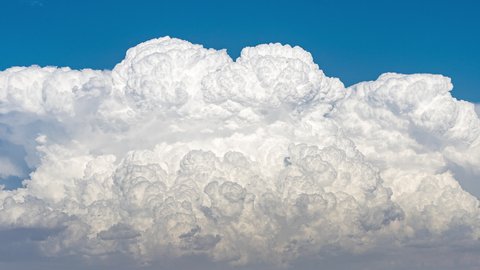 Close up time lapse of a large Cumulonimbus cloud growing and transforming into an Anvil cloud