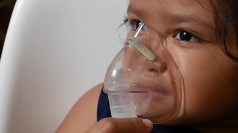 Asian girl is being nebulized to cure her respiratory tract