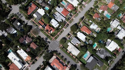 Aerial shot of a Miami neighborhood, Clean and big streets on a sunny day with houses and swimming pools in South Florida. 