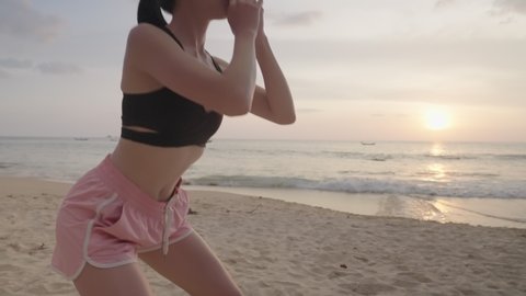 Young fit girl doing squat on the beach with sunset, active asian young adult female work out with relaxing environment, bodyweight training exercise for woman, island beach shores, self motivation 