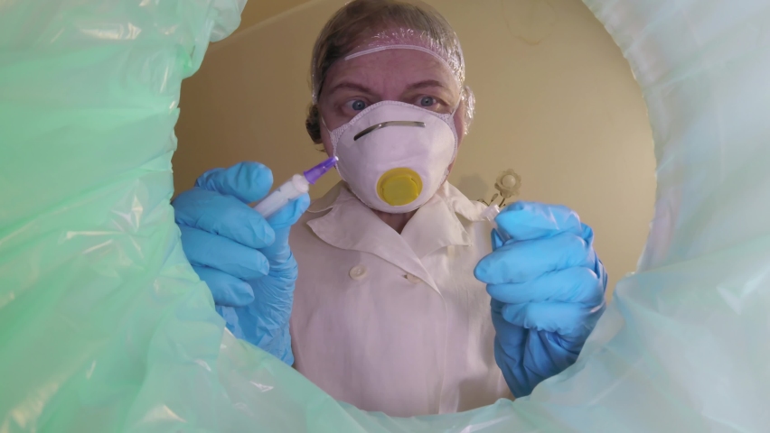 Woman doctor in medical respirator with hight protection throwing used medical trash in bin away, trash bin with pills, medical mask, galsses inside, medecine in trashcan