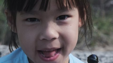 Cute little girl eating lollipops. Happy little Asian girl enjoys eating lollipops.