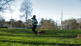 Young girl is running in park with her pet. Slow motion.