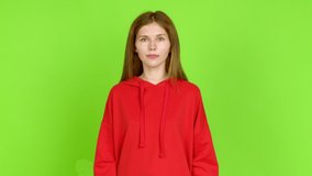 Young woman standing and thinking an idea pointing the finger up over isolated background. Green screen chroma key