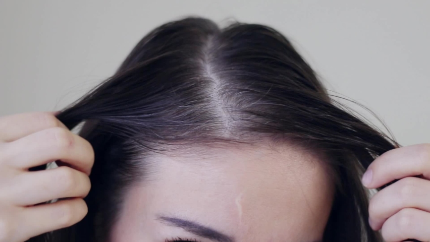 Young woman shows her gray hair roots. View from above. Close-up. Royalty-Free Stock Footage #1087847593