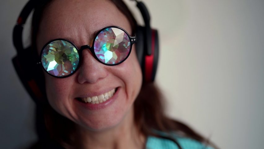 happy woman is enjoying music by headphones, smiling broadly, good mood and fun