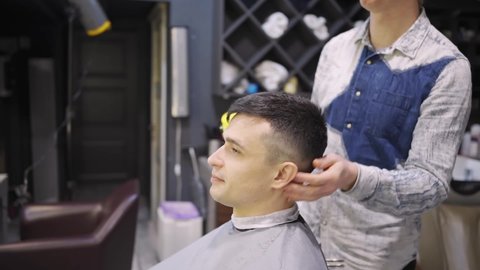 the hairdresser hair dryer brunette man in a barbershop. professional services. beauty salon for men. cosmetics and products for scalp and hair care.