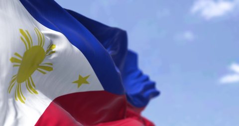 Detail of the national flag of the Philippines waving in the wind on a clear day. The Philippines is an archipelagic country in Southeast Asia. Selective focus.  Seamless looping in slow motion