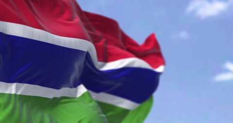 Detail of the national flag of Gambia waving in the wind on a clear day. Gambiac is a country in West Africa. Selective focus. Seamless slow motion