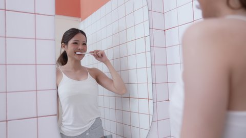 Daily routine concept of 4k Resolution. Asian woman brushing teeth in the bathroom. oral hygiene. prevention of tooth decay. gum health. food waste and limestone.