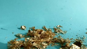gold leaf - gold leaf falling and floating down to blue turquoise background in slow motion in reverse - Powered by Shutterstock - Get 15% off with code: PIKWIZARD15