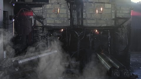 Old Glass Marble Making Machine and Furnace in a Glass Marble Factory, Large Machine making Glass Toy Marbles Dropping Molten Glass on Iron Rolls.