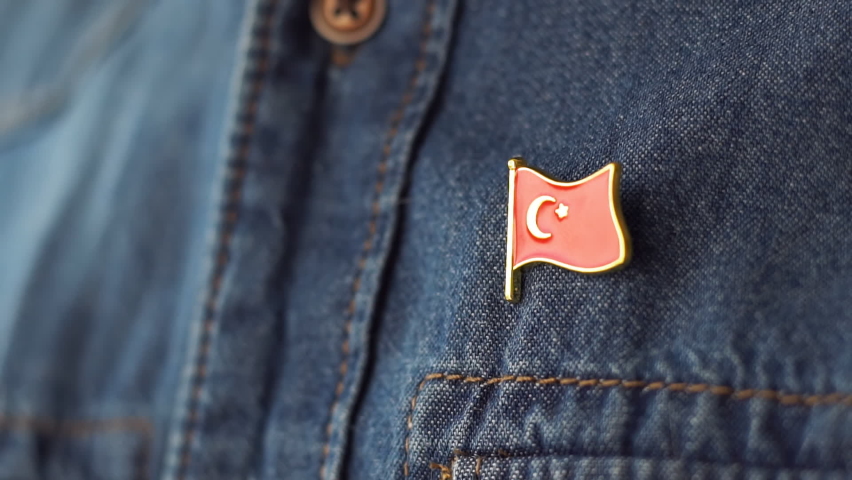 Turkish flag icon is pinned on blue jeans jacket. Turkey patriotism concept. Republic Day Holiday in Turkey. Royalty-Free Stock Footage #1087859083