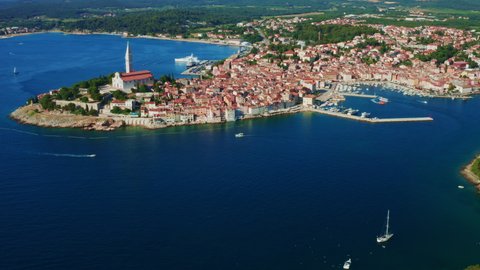 Croatian town Rovinj with historical buildings and Church of St. Euphemia. Istria peninsula surrounded by water of Adriatic sea in summer. Aerial view