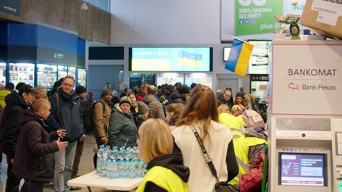 Warsaw, Poland - March 3, 2022: Volunteers greet war refugees from Ukraine at reception center. Polish people care, feed and serve humans in need welcoming them in Europe, responding human disaster