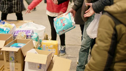 Warsaw, Poland - March 3, 2022: War refugees from Ukraine take free hygiene products in reception center. Social care and service for people in Europe. Human disaster response.