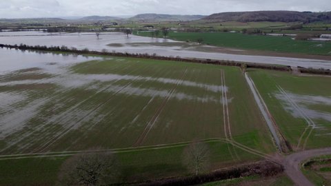 Huge areas of farmland flooded with rain water UK aerial drone panning shot
