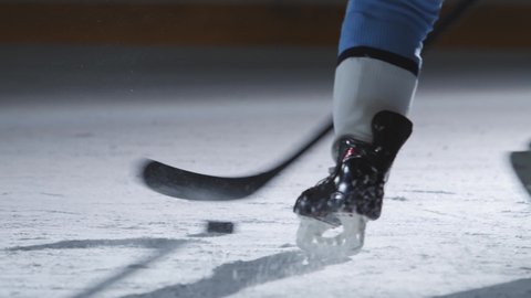 Feet close up of two hockey players using their hockey sticks to win the puck, winter sports background