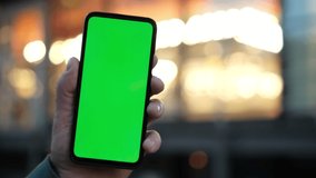 Handheld Camera: Point of View of man at street Using Phone With Green Mock-up Screen Chroma Key Surfing Internet Watching Content Videos Blogs Tapping on Center Screen