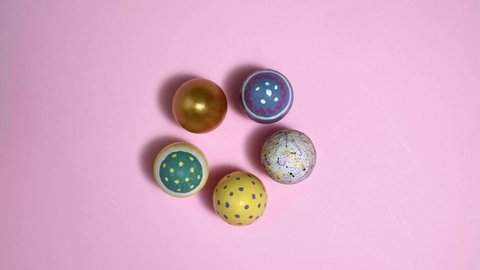 4k. Rotating colorful Easter eggs in circle on pink background. Eggs Inulticolored egg for Happy easter. Hello spring and Happy Easter holiday concept. Top View
