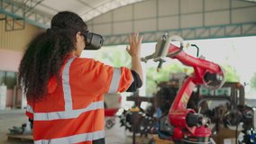 Young Africa American engineer is controlling Futuristic robotic arm with a virtual reality Headset. Testing robot by moving hand at factory. VR Technology industrial and modern equipment. - Powered by Shutterstock - Get 15% off with code: PIKWIZARD15