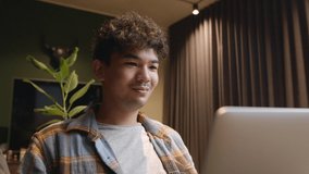 Mixed race male working from home smiling while communicating with clients 