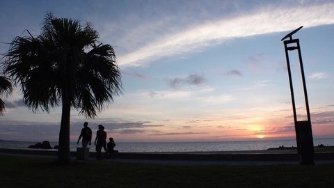CHATAN-CHO, OKINAWA, JAPAN - AUG 2021 : View of Araha beach (Ocean or sea) in sunset time. Wide view, long time lapse shot, dusk to night. Summer holiday, vacation and resort concept shot.