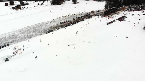 Crowded skiing slope. Many people skiing and snowboarding during their winter holidays. Aerial View. High quality 4k footage