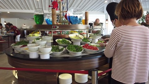 Turkey, Belek, 1 November,2021. Lunch at the hotel's buffet dining room. People choose food. The staff wear protective medical masks.