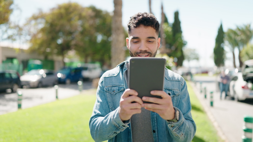 Young arab man smiling confident having video call at park
