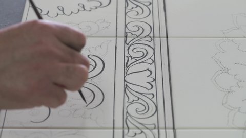 artist paints on Vietri ceramic tiles