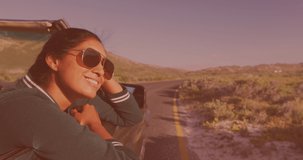 Animation of happy biracial woman wearing glasses, driving a cabriolet. travel, holidays and freedom concept digitally generated video.