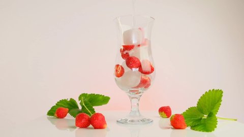 Strawberry drink.slow motion.Sparkling mineral water with ice and strawberries