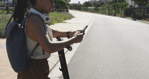 Animation of data processing over biracial woman using smartphone with scooter in park. health and fitness concept digitally generated video.