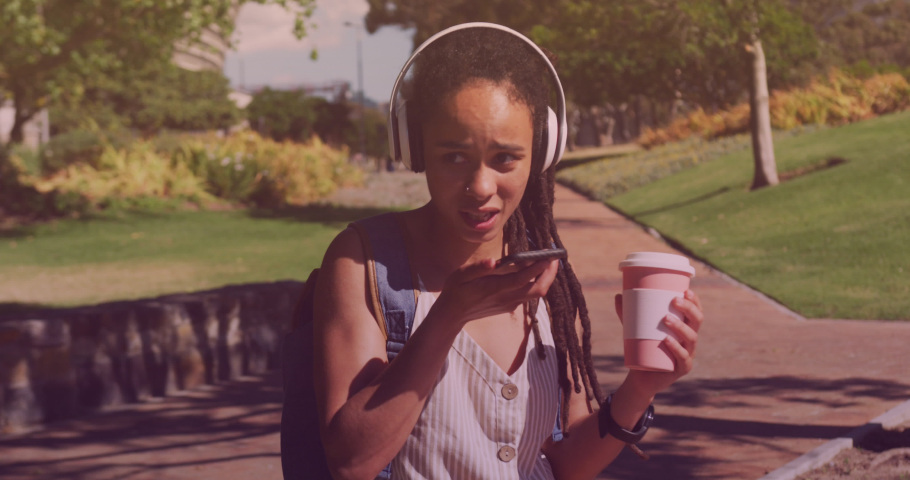 Animation of smartphone icon over biracial woman talking on smartphone in park. health and fitness concept digitally generated video.