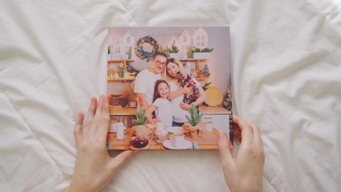 hands scroll through pages of photobook on white background. family photo shoot. professional printing of photos and albums in printing, photo laboratory. photographer and designer services. memory.