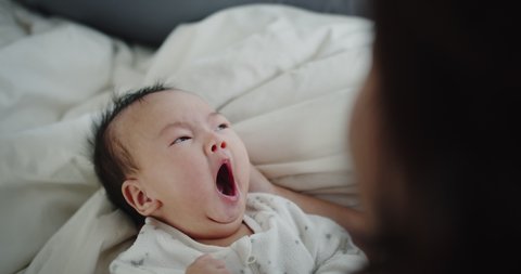 Close up adorable newborn baby infant child girl Yawning on the bed in the morning at home, family, children, parenthood, childhood, life, love concept