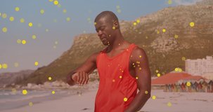 Animation of spots over african american man using smartwatch at beach. health and fitness concept digitally generated video.