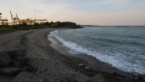 Nice 4k video of waves of the black sea crashing on the sandy shore in the evening