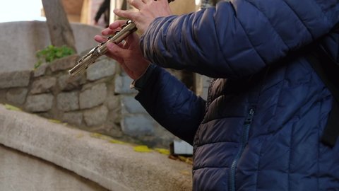 Hands of unrecognizable man playing flute. Street musician plays flute