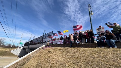 DAYTON, OHIO - MARCH 3: People sitting at overpass waiting for Truck Convoy to Washington DC to protest vaccine mandates and to support re-opening the country, taken in Dayton, Ohio on March 3, 2022.